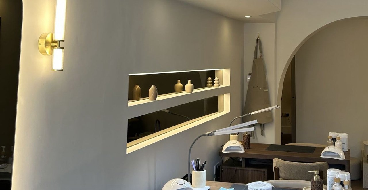The Envy salon at 47 Bulfin Road: a brass wall light, a lit niche, the nail desk and an arch